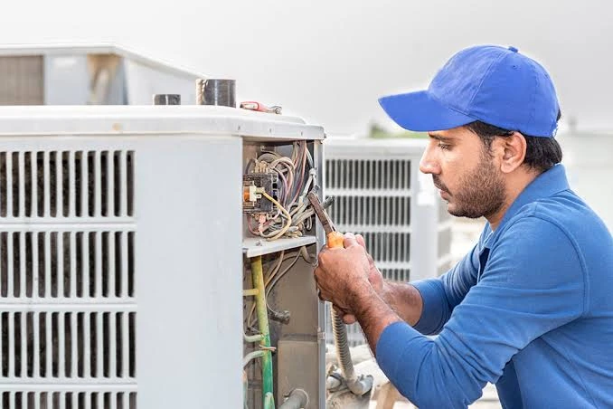 Technician servicing the electrical panel of an air conditioner